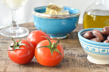 Fresh tomatoes with other Mediterranean ingredients, on the rustic background, Greek food