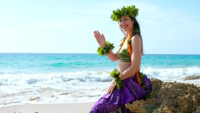 Pretty and smiling woman shakes hand to say hello and greets clients to receive them on the beach. Nice welcome for tourists. Attire hula dancer biki lady.