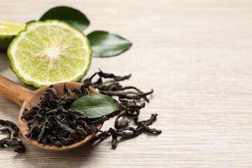 Dry bergamot tea leaves and fresh fruit on light wooden table, closeup. Space for text