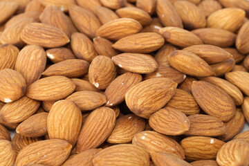 close up of raw brown almonds nuts pile,edge blur  . vegan organic almond nut with hight protein and vitamin. healty eating and seed for agriculture concept