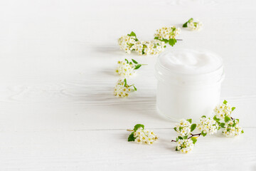 Fototapeta na wymiar Herbal facial cream cosmetic for skin care with white flowers