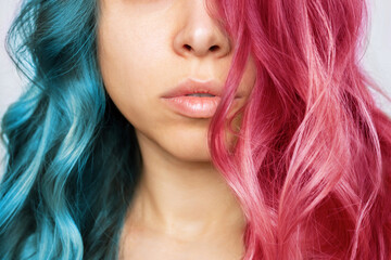 Close-up of the wavy half pink and half blue hair of a young woman isolated on a white background....