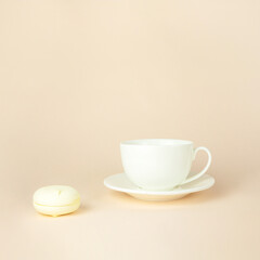 Close up French delicate dessert for Breakfast with porcelain white coffee cup mug on beige pastel background. Gourmet Colored Cookies.