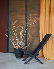A black chair in the loft style interior. Plants decorate the room.