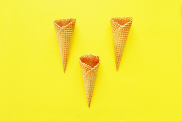 three waffle cones on yellow background