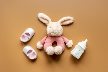 Baby girl pink shoes with milk and toy. Newborn set background