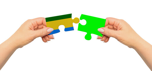 Woman hands are holding part of puzzle game. National mock up on white background. Gabon