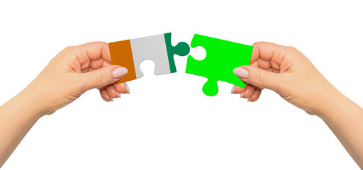 Woman hands are holding part of puzzle game. National mock up on white background. Ivory Coast