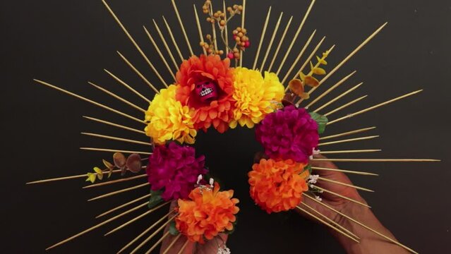 Showing a flower headband. Day of the dead. Mexican celebration. Religion and culture. D�a de los muertos. Brown skin hands. 