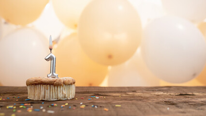 Happy birthday card with candle number 1 in a cupcake against the background of balloons. Copy...