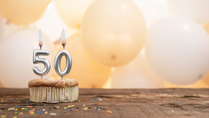Happy birthday card with candle number 50 in a cupcake against the background of balloons. Copy...