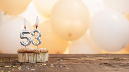 Happy birthday card with candle number 53 in a cupcake against the background of balloons. Copy...