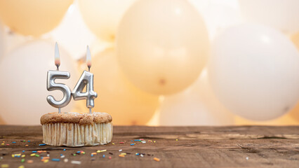 Happy birthday card with candle number 54 in a cupcake against the background of balloons. Copy...
