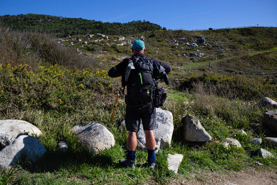 A pilgrim rests on the Portuguese Camino de Santiago along the coast in A Guarda