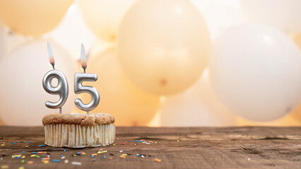  Happy birthday card with candle number 95 in a cupcake against the background of balloons. Copy space happy birthday for ninety five years old - obrazy, fototapety, plakaty