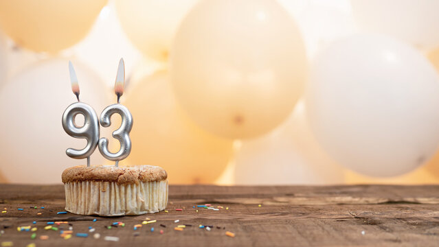 Happy birthday card with candle number 93 in a cupcake against the background of balloons. Copy space happy birthday for ninety three years old