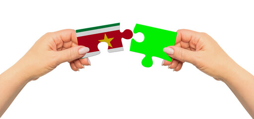 Obraz premium Woman hands are holding part of puzzle game. National mock up on white background. Suriname