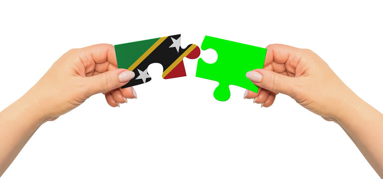 Woman hands are holding part of puzzle game. National mock up on white background. Saint Kitts and Nevis