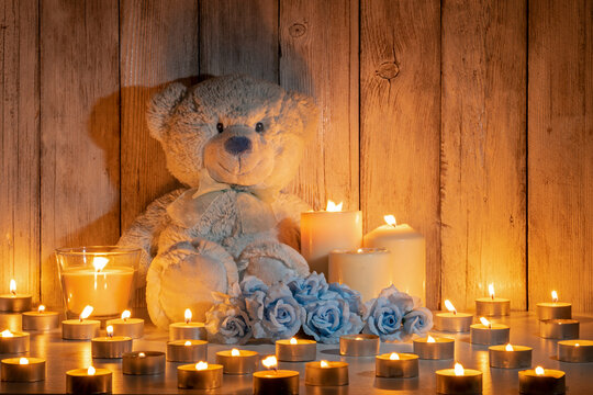TEDDY BEAR, ROSES AND CANDLES. BABIES AND CHILDS DEATH. DECEASED CHILDREN FUNERAL. COPY SPACE.