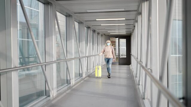 a young woman with a travel suitcase at the airport is boarding a plane. travel concept.