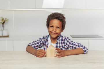 Naklejka premium Happy kid boy showing blank wooden house