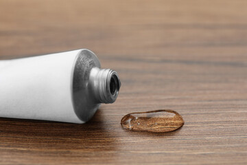 Open white tube with ointment on wooden table, closeup - obrazy, fototapety, plakaty