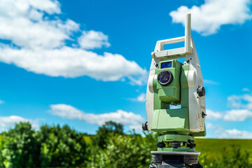 Surveyors equipment (theodolite or total positioning station) on the construction site of the road,...