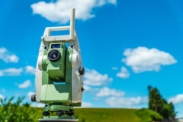 Surveyors equipment (theodolite or total positioning station) on the construction site of the road, highway or building with construction machinery background
