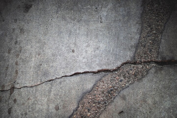 Scratched and cracked grunge concrete background with stones gravel cracks and dirt
