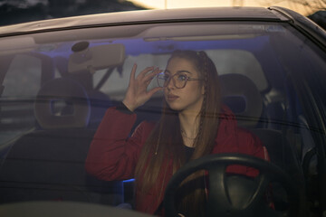 girl in her early twenties in a car just before dark