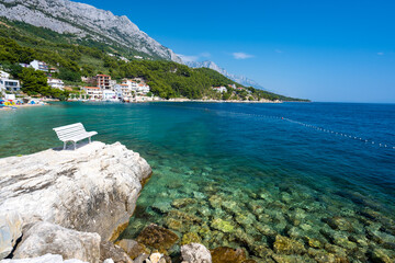 amazing coast with white bench in Brela on Makarska riviera in Dalmatia in Croatia
