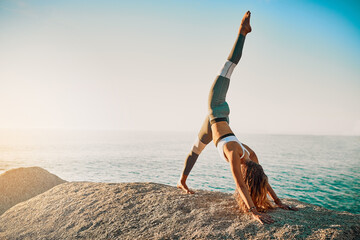 Dont ever doubt in yourself. Shot of an athletic young woman practicing yoga on the beach.