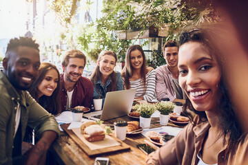 Always up for a work selfie. Shot of a woman taking a selfie with her colleagues while out for lunch.
