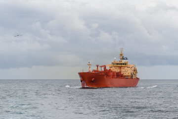 Tanker at sea. Cargo vessel with red hull sailing.