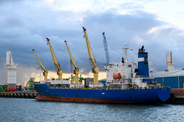 Blue refrigerated cargo vessel moored in port. Loading of cargo.