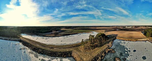 Panorama.Aerial view of fish ponds on a sunny day among the fields and forest of the Polish countryside.