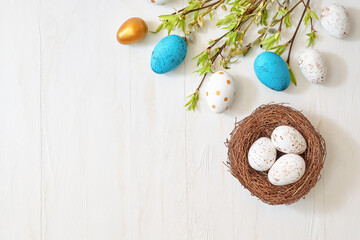 Branches with green leaves and easter eggs on a light background. Happy easter flat lay concept