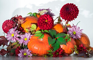 Thanksgiving pumpkins with flowers and autumn leaves. Autumn background