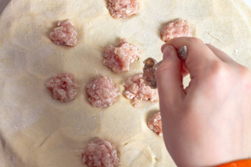 Making homemade dumplings, lay out minced meat with a spoon in the dough on the dumpling