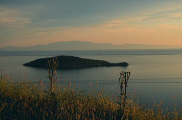 sunset over the sea with an island