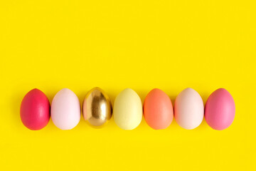 Easter banner with colorful Easter Egg in a row. Border over a yellow background. Above view with copy space. Easter decorated eggs frame. Happy Easter card. Top view, flatlay