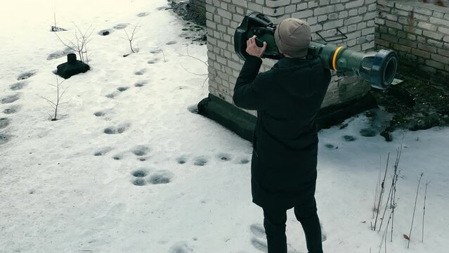 A man with an anti-tank weapon in an abandoned house. Civilian population with weapons to destroy tanks.