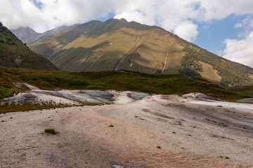 Colorful landscape with mineral springs on ground in Truso Gorge in Kazbegi district, Mtskheta-Mtianeti region, Georgia. Truso Valley in the Greater Caucasus Mountains. Geyser, volcanic. Wanderlust.