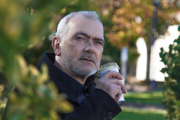 relaxed man having a coffee in the park