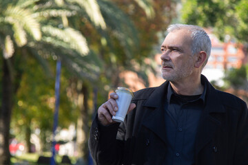 relaxed man having a coffee in the park