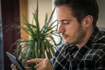 young man using digital tablet at home