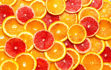 Photo of sliced tropical fresh colorful citrus fruits orange and red grapefruit in pattern flat lay creative modern style shot in studio