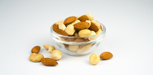Mix of nuts in a glass bowl isolated on white background. Healthy food. Banner. Close-up.