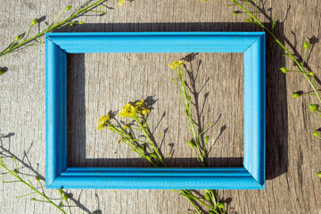 a blue wooden frame is placed horizontally on a gray wooden surface