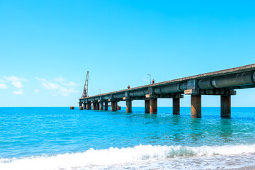 Fototapeta na wymiar seascape on the coast, blue sea and blue sky, old pier on the horizon